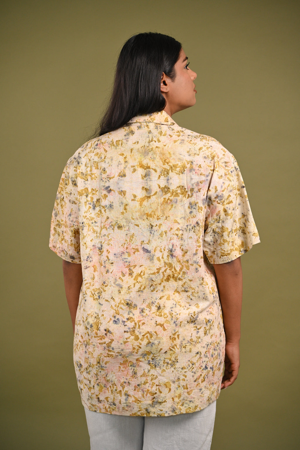 Back view of the Iris Shirt, featuring subtle yet intricate eco-prints of madder root, rose petals, and marigold petals on breathable, handwoven Kala Cotton.