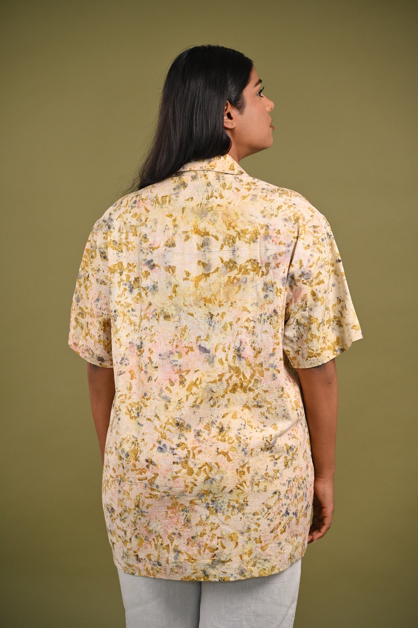 Back view of the Iris Shirt, featuring subtle yet intricate eco-prints of madder root, rose petals, and marigold petals on breathable, handwoven Kala Cotton.
