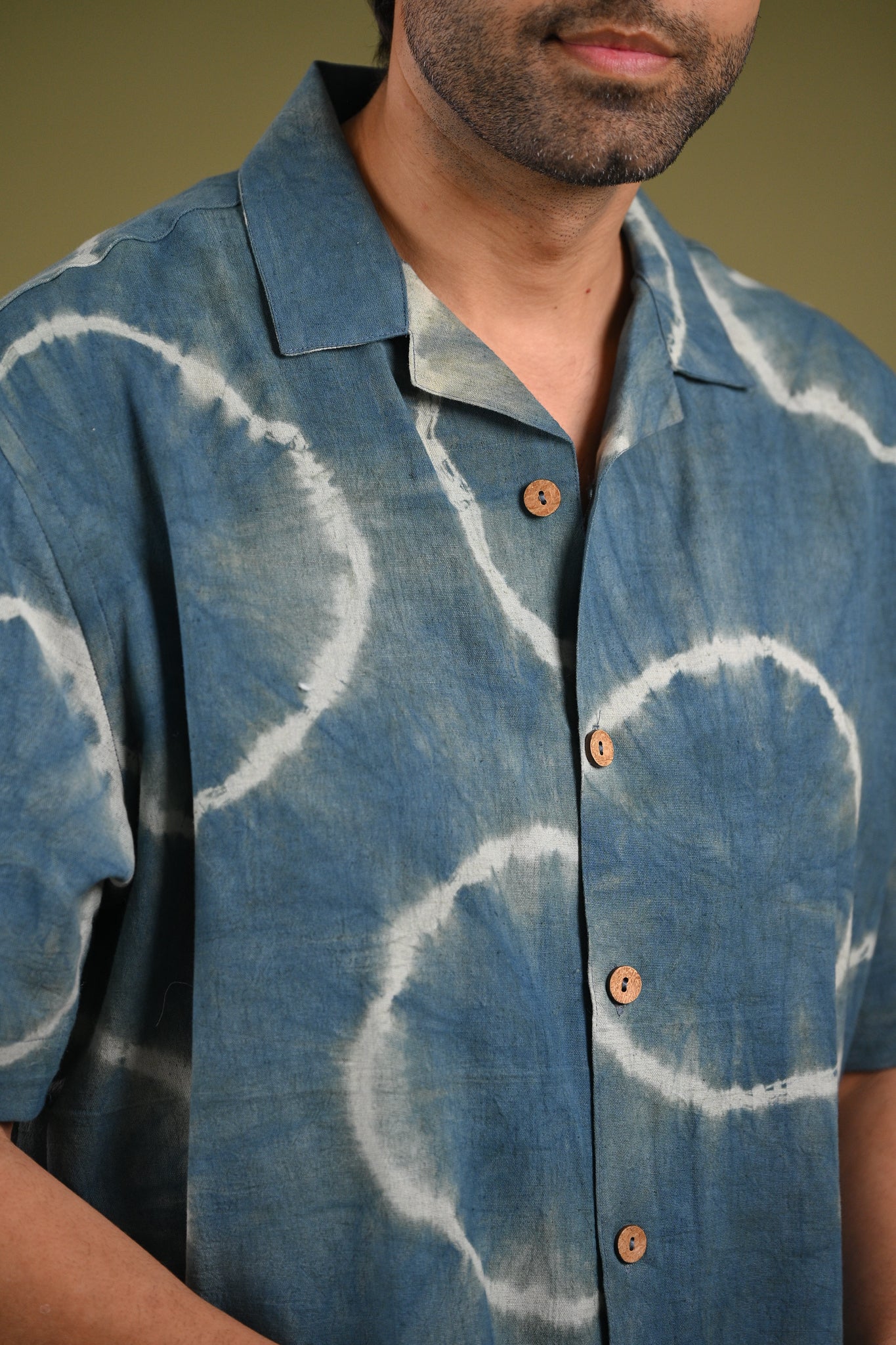 Close-up of the Nilima Shirt’s Shibori resist-dyed patterns in rich natural indigo, highlighting the organic texture and artisanal craftsmanship.